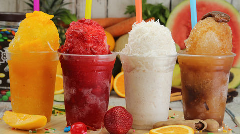 Fruit-filled paleta display case with mango, tamarind, and coconut flavors on bright yellow background