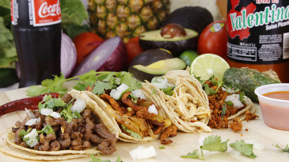 Birria tacos dipped in rich consomé broth with melted cheese and fresh herbs