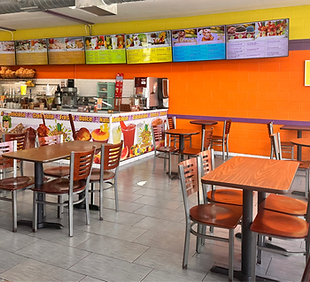 Paleteria El Chavo staff smiling behind the counter, bright yellow walls and welcoming atmosphere